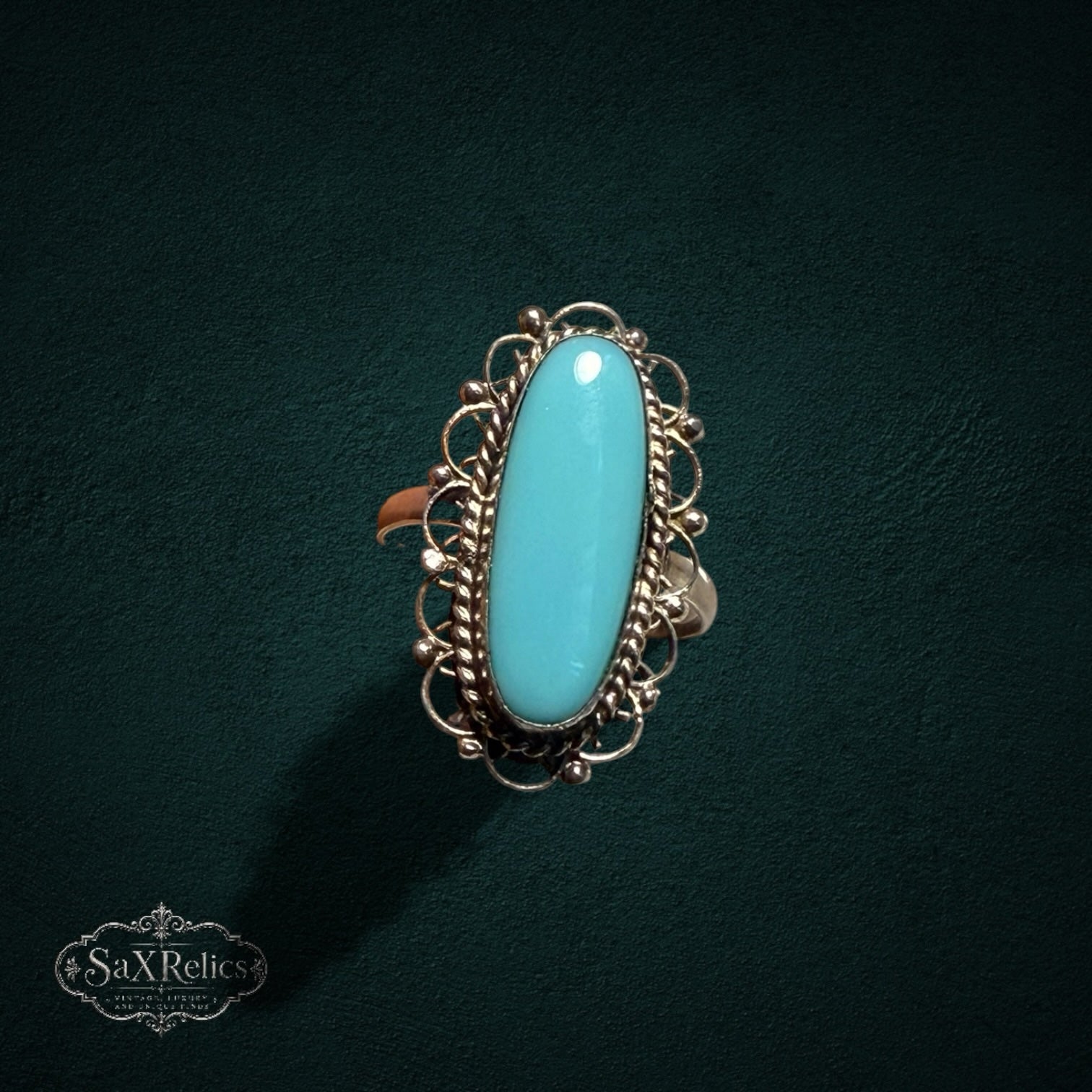My Store SAXRelics vintage sterling silver ring with an elongated oval turquoise cabochon and intricate filigree detail.