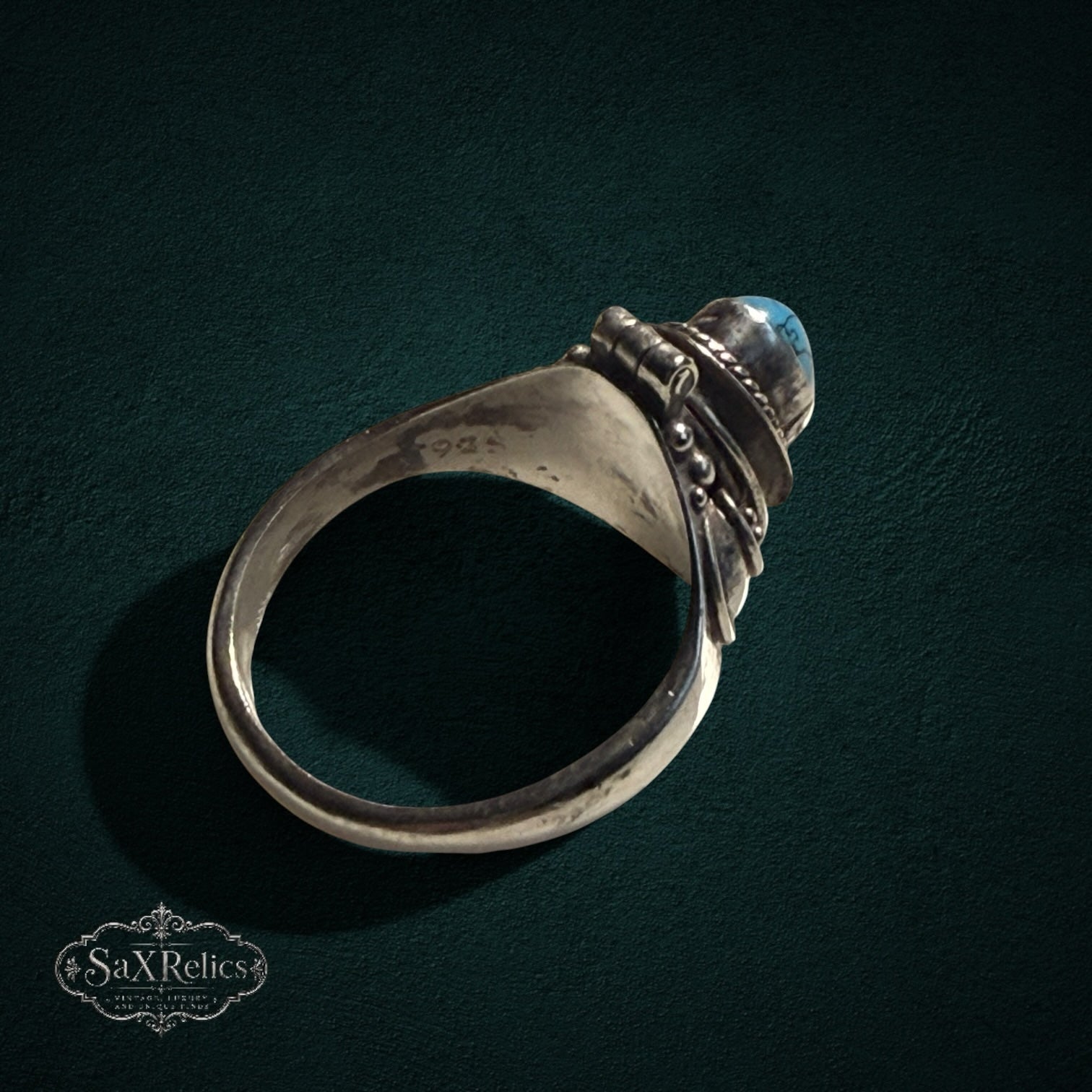 My Store vintage style sterling silver poison ring with a hinged turquoise stone compartment and intricate scrollwork.