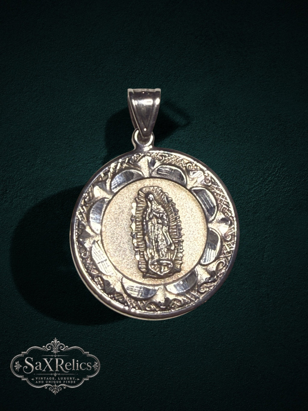 Religious pendant featuring an intricate Virgin of Guadalupe medallion with an ornate textured border