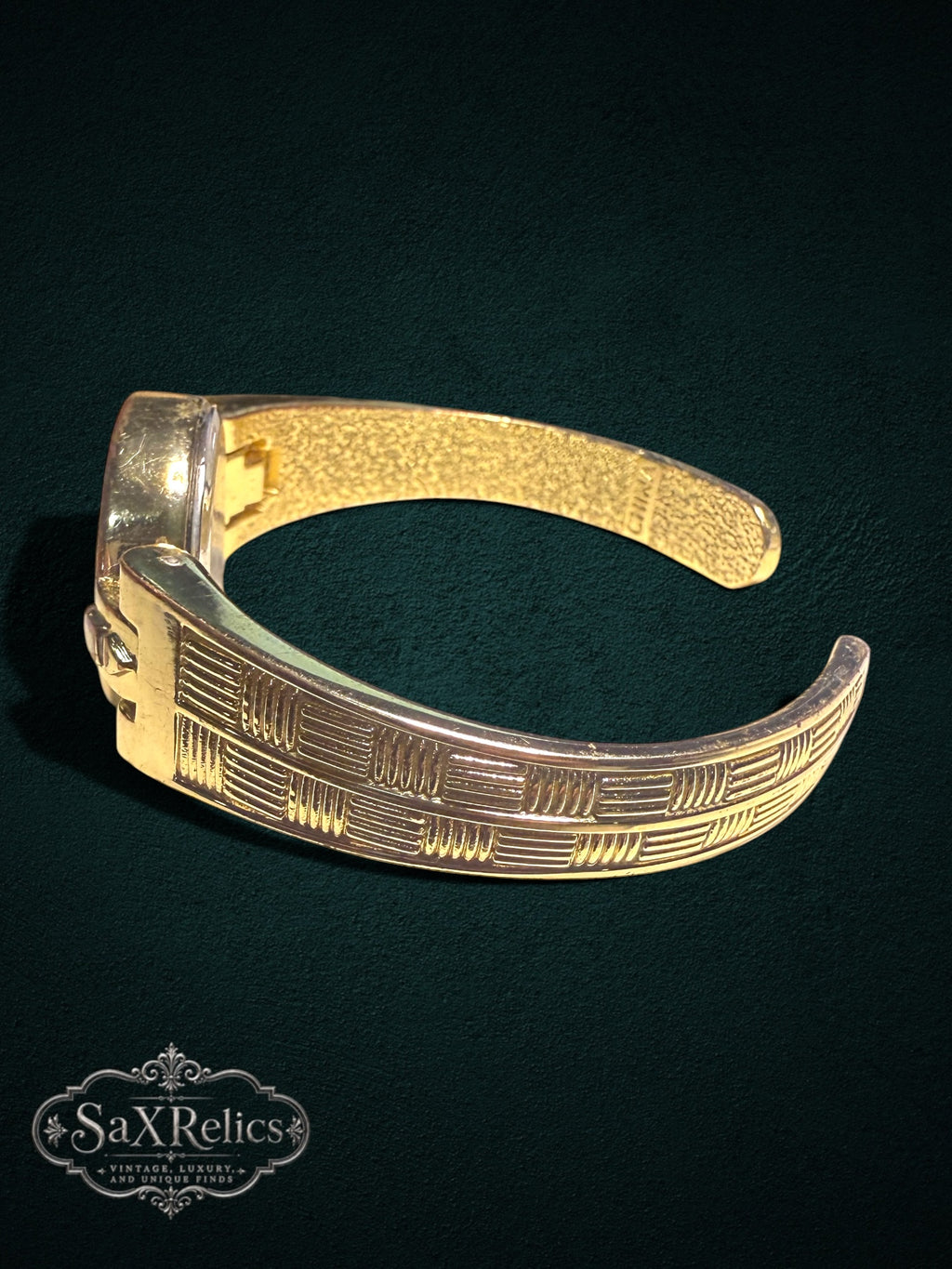 My Store Vivani gold-tone cuff watch with textured geometric band and open-cuff design on a dark background.