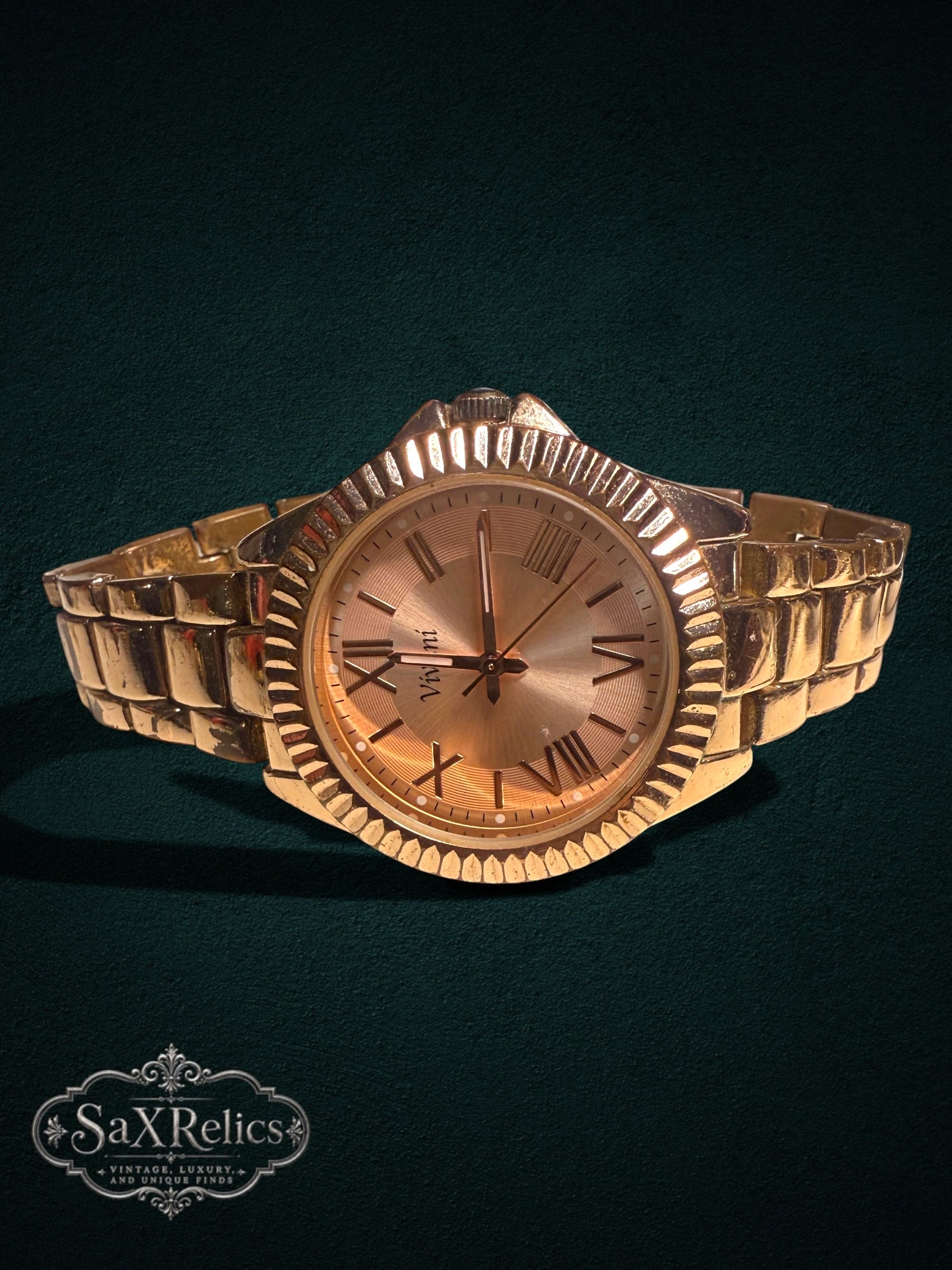 My Store Vivani gold-tone metal link wristwatch with a fluted bezel and Roman numeral dial on a dark background.