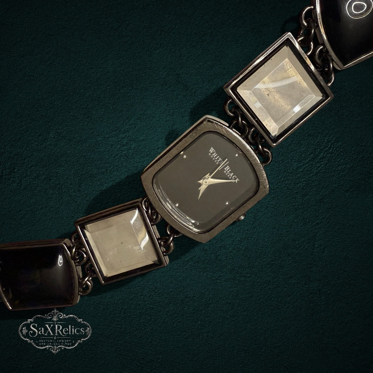 My Store White House Black Market link watch with square glass and black resin accents on a dark green background.