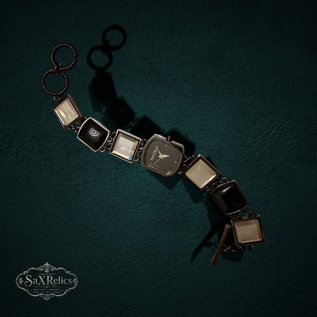 My Store White House Black Market link wristwatch with square glass and black resin accents on a dark green background.