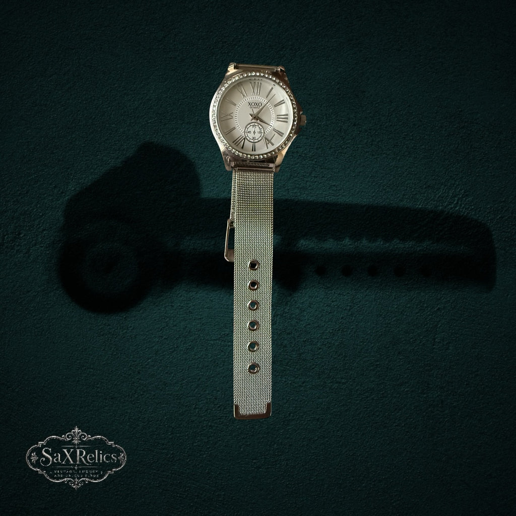 My Store XOXO silver-tone quartz wristwatch with crystal-adorned bezel, white dial, Roman numerals, and mesh strap.