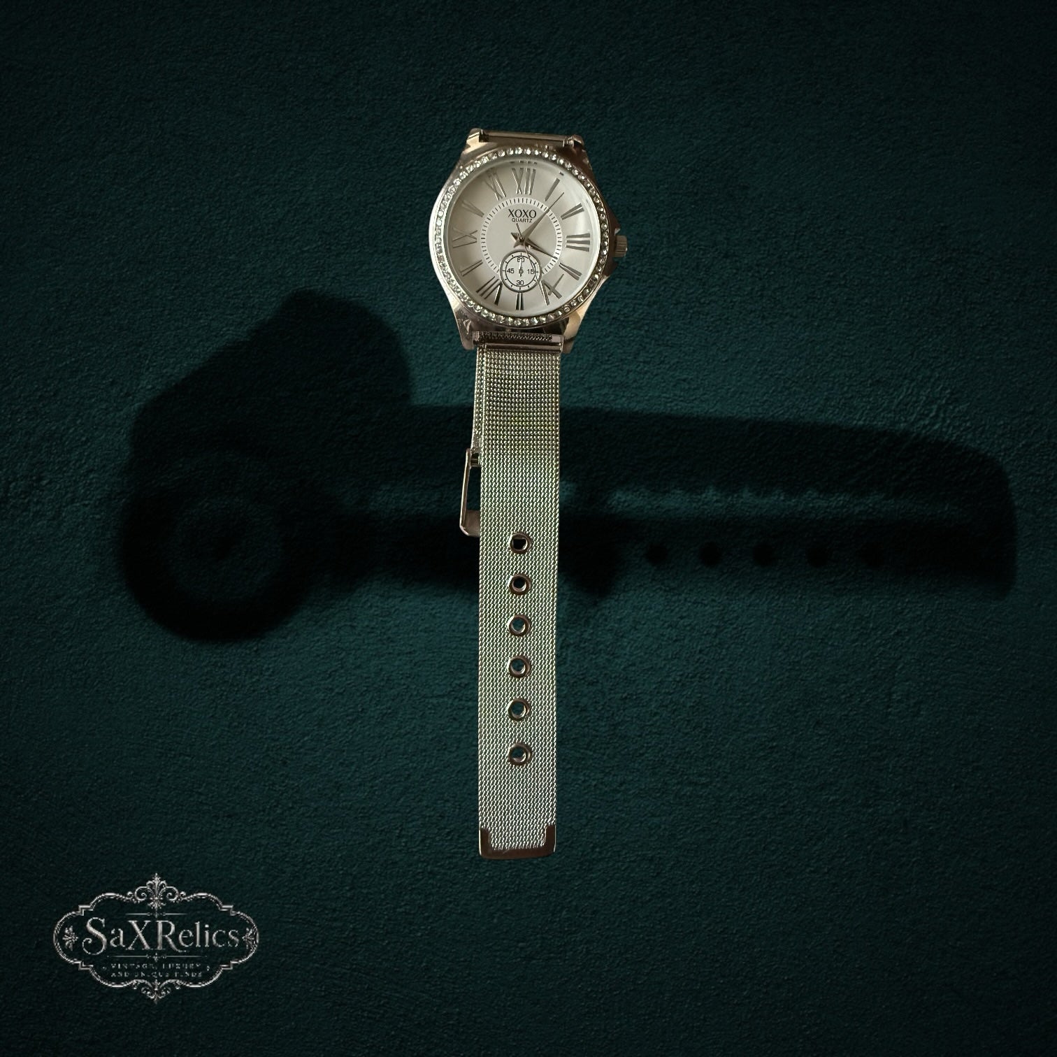 My Store XOXO silver-tone quartz wristwatch with crystal-adorned bezel, white dial, Roman numerals, and mesh strap.